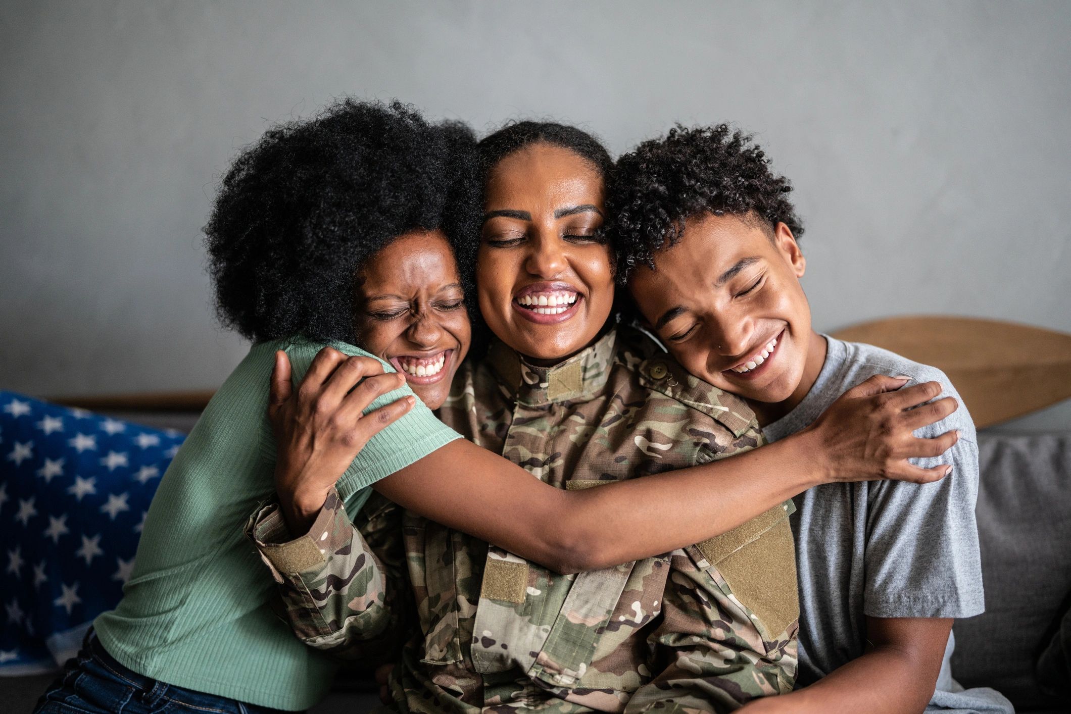Soldier mother embracing her children at home